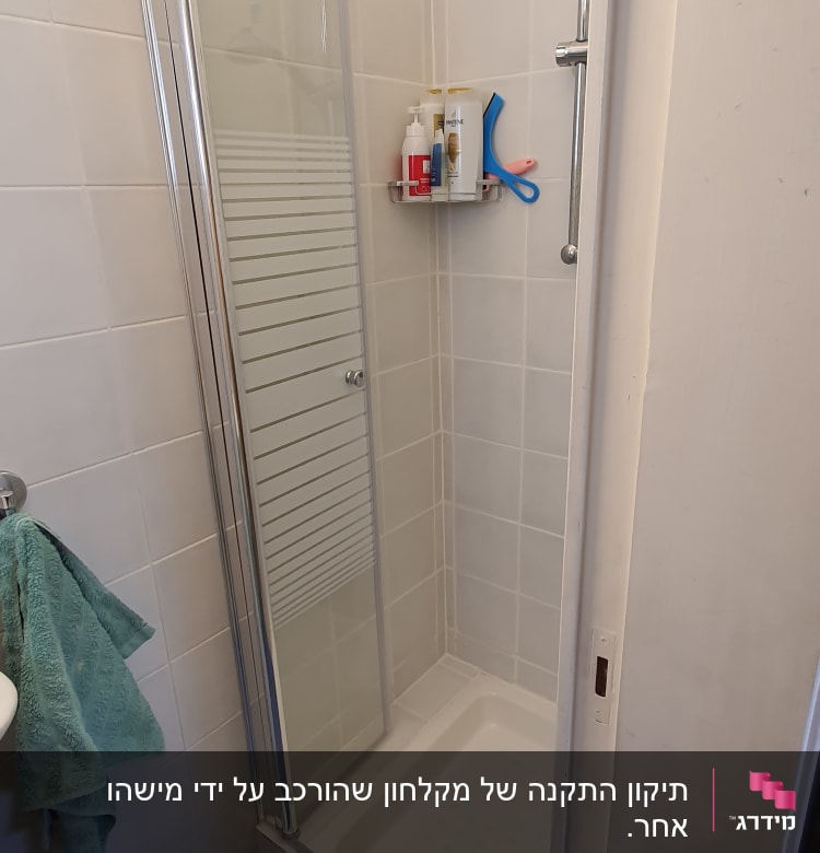מקלחון עם מדף מוצרים ומגבת תלויה